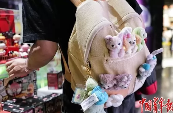 中青报聚焦包挂风潮：年轻人的背包仿佛挂满了整个世界-第1张图片-